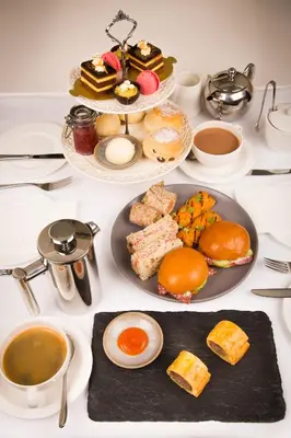 a table with plates of food and cups of coffee at Fishmore Hall Hotel and Boutique Spa in Ludlow