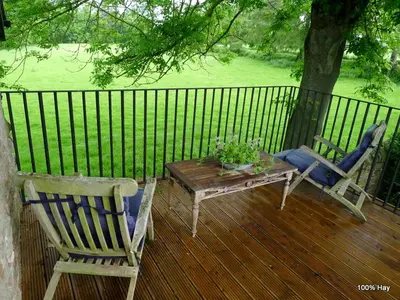 two chairs and a table on a deck with a fence at Glanwye in Hay-on-Wye