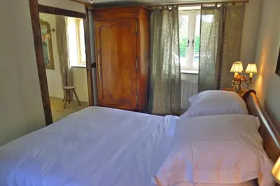 a bedroom with a bed with white sheets and a window at Glanwye in Hay-on-Wye