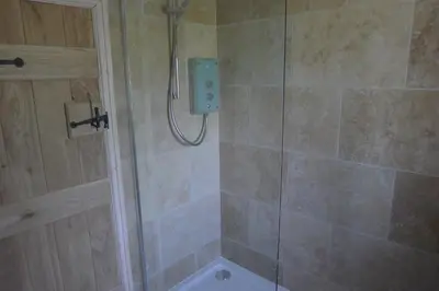 a bathroom with a shower with a glass door at Glanwye in Hay-on-Wye