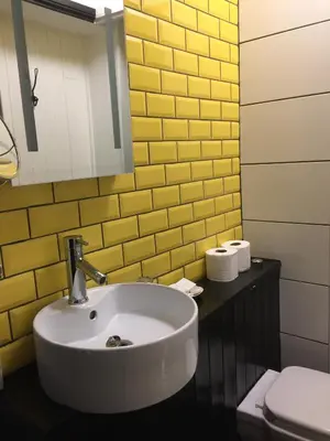 a bathroom with a sink and a yellow wall at Greenbank Lodge LLANGOLLEN in Llangollen