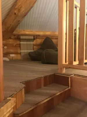 a stairway leading into a room with a bed at Coed y Marchog Woodland Retreat in Hereford