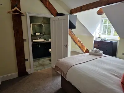 a bedroom with a bed and a bathroom with a sink at Devils Falls at the Luxury Hafod Hotel Aberystwyth in Devils Bridge
