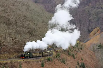 a steam train with smoke coming out of it at Devils Falls at the Luxury Hafod Hotel Aberystwyth in Devils Bridge