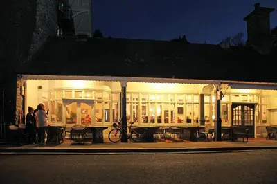 a group of people standing outside of a building at night at Devils Falls at the Luxury Hafod Hotel Aberystwyth in Devils Bridge