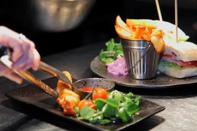 a person is serving food on two plates with food at Devils Falls at the Luxury Hafod Hotel Aberystwyth in Devils Bridge