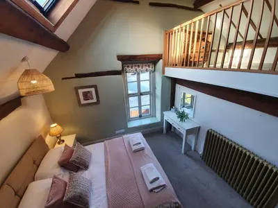 an attic room with a bed and a staircase at The Castle Hotel in Bishops Castle