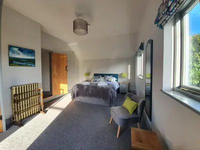 a bedroom with a bed and a chair at The Castle Hotel in Bishops Castle