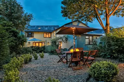 a patio with a table and chairs and an umbrella at The Coach House Brecon in Brecon