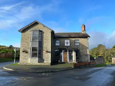 an old brick building on the corner of a street at Castle Inn in Knighton