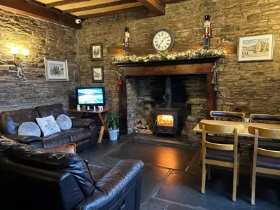 a living room with a fireplace and leather furniture at Castle Inn in Knighton