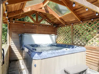a large jacuzzi tub in a wooden house at Penuwch Fach in Llanfihangel-y-creuddyn