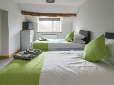 two beds in a room with green and white at Bryndan in Machynlleth