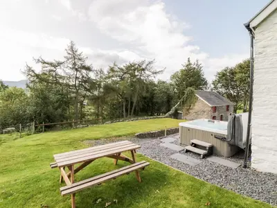 a picnic table and a grill in a yard at Bryndan in Machynlleth