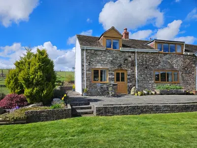 a stone house with a lawn in front of it at Nant-Isa in Shelve