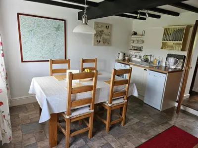 a kitchen with a table and chairs in a kitchen at Nant-Isa in Shelve