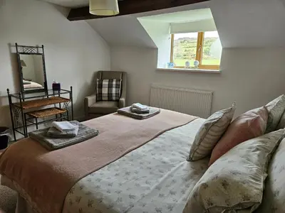 a bedroom with a large bed with two towels on it at Nant-Isa in Shelve