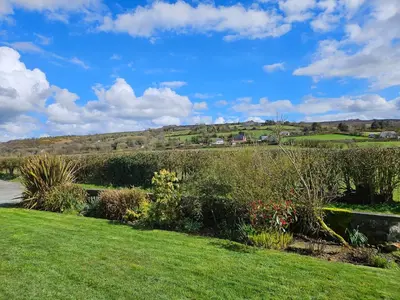 a view of a garden with a hill in the background at Nant-Isa in Shelve
