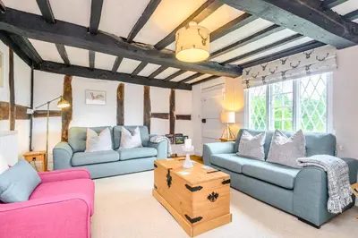 a living room with two couches and a table at Fern Hall Cottage in Upper Welson
