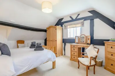 a bedroom with a bed and a desk and a chair at Fern Hall Cottage in Upper Welson
