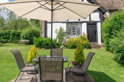 a table and chairs with an umbrella in a yard at Fern Hall Cottage in Upper Welson