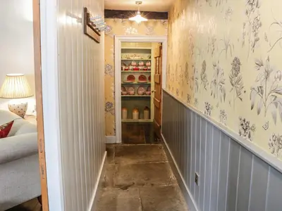 a hallway with blue and white wallpaper and a shelf at Fern House in Craven Arms