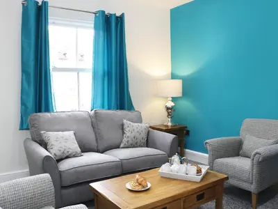 a living room with a couch and two chairs at 7 Monkmoor Road in Shrewsbury