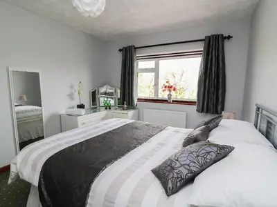 a bedroom with a large bed and a window at Blaenywawr in Cross Inn