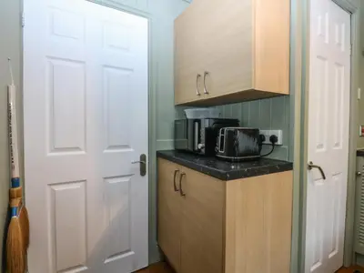 a kitchen with a counter and a microwave and a door at Maesawel Studio in Harlech