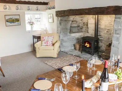 a living room with a fireplace and a table with wine glasses at Lower Hodre in Bucknell