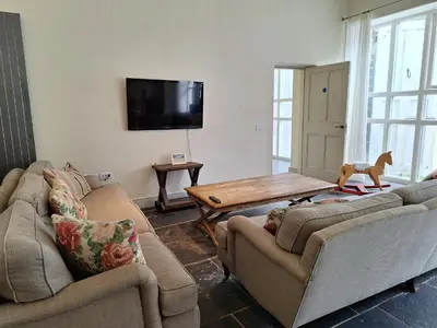 a living room with two couches and a table at Plas Nanteos Mansion in Aberystwyth