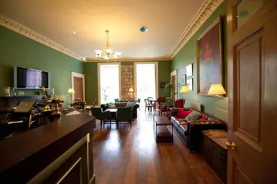 a living room with green walls and a couch at Plas Nanteos Mansion in Aberystwyth