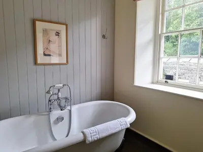 a white bath tub in a bathroom with a window at Plas Nanteos Mansion in Aberystwyth