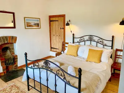 a bedroom with a bed in a room with a fireplace at Pant Dafydd Goch in Glyn-Ceiriog