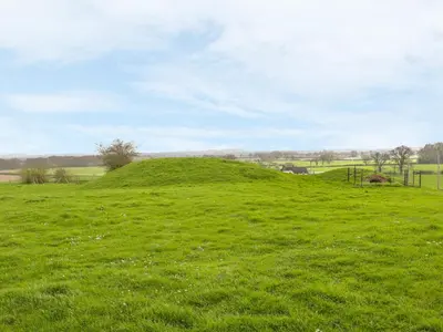 a green grassy hill in a field at Acorn Cottage 2 in Petton
