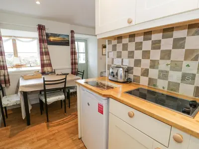 a kitchen and dining room with a table in the background at Happy Landing in Harlech