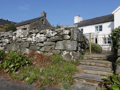 a stone retaining wall in front of a house at Happy Landing in Harlech