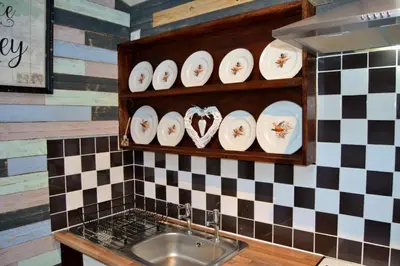 a kitchen with a sink and a checkered wall at Arrowwood Self Catering (Wagtail and Nuthatch) in Kington