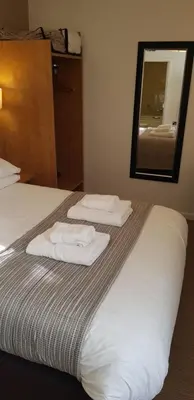 a hotel room with two folded towels on a bed at The Wellington in Brecon