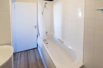 a white bathroom with a tub and a sink at The Wellington in Brecon
