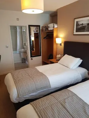 a hotel room with two beds and a bathroom at The Wellington in Brecon