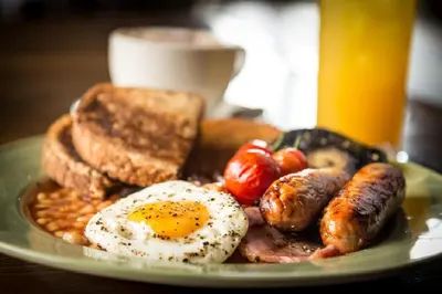 a plate of breakfast food with eggs sausage and toast at The Wellington in Brecon