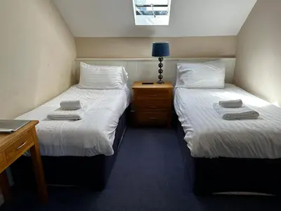 two beds sitting next to each other in a room at Castle Hotel in Aberaeron