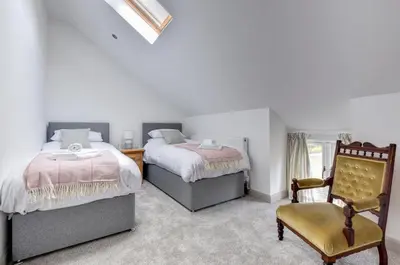 a bedroom with two beds and a chair at 2 Bed in Machynlleth oc-bow39 in Darowen