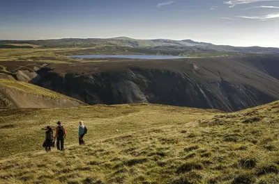 three people walking on a hill with a view of a mountain at 2 Bed in Machynlleth oc-bow39 in Darowen
