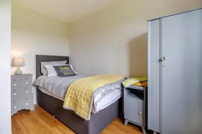 a small bedroom with a bed and a dresser at 3 Bed in Bala oc-bow26 in Llanuwchllyn