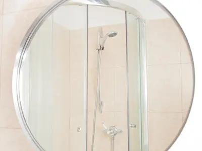a shower in a bathroom with a round mirror at The Loopy Shrew in Shrewsbury