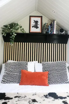 a bed with a black and white striped headboard and two pillows at Nant Cafn - Hafan Hideaways Eryri in Machynlleth