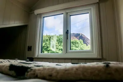 a bedroom window with a view of a mountain at Nant Cafn - Hafan Hideaways Eryri in Machynlleth