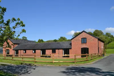 a large red brick building with a black roof at 1 Bed in Llandinam oc-waa376 in Llandinam